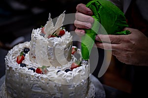 Decorating cream cake and fruits