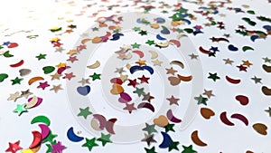 Decorating glitter sparkles in stars, heart and half moon shape stones with white background