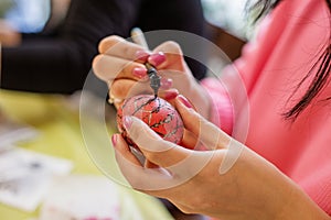 Decorating Red Easter Egg with Black Wax Patterns