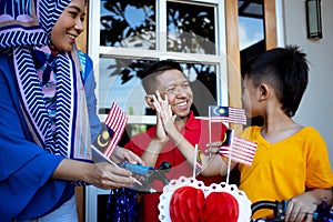 Decorating son`s bicycle with malaysia flag