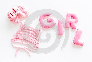 Decoration for baby`s birthday. Word girl near booties on white background top view