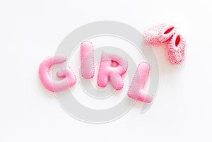 Decoration for baby`s birthday. Word girl near booties on white background top view