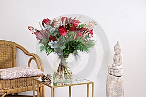 Decoration with bouquet of red flowers in glass vase photo