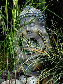 Decoration buddha statue little in a garden outdoor covered with grass