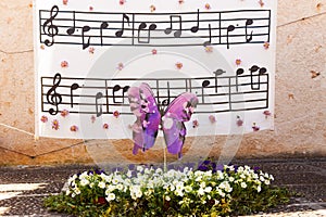 Decoration with a butterfly over a flowerbed with some musical notes in the background on \