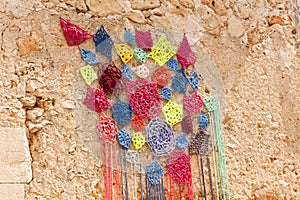 Decoration, consisting of colorful crochet dreamcatchers on the stone wall