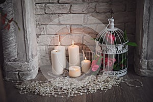 Decoration of fretwork fireplace with flowers, candles and bead