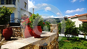 The decoration on Greek street - large bright clay flower pots and geraniums in it.