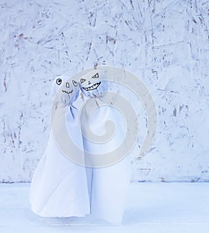 Decoration for Halloween. Two ghost figures on light background. Handmade decor for party.