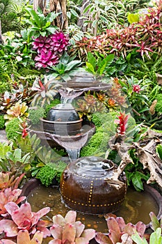 Decoration jar with the fountain in the garden. Decorative jar with fountain  look like waterfall with flowers and tree plant in