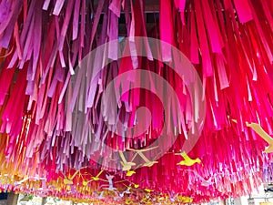 Decoration multi color hanging long paper on ceiling. yellow plastic birds hanging for decoration. vivd pink and violet color