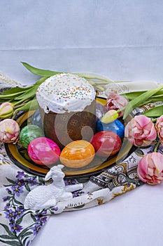 Decoration with Orthodox Easter cake, Easter eggs, tulips and ceramic lamb.