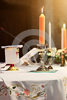 Decoration on the wedding table with candle, Rose vase,book, pen in Christian marriage. Wedding ceremony in christian church