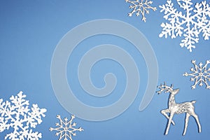 Decoration white snowflake on blue background. Christmas deer Top view