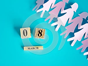 Decoration of wooden date blog cube for 8 March , international women`s day with a paper craft women shape on blue for celebratio