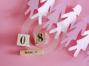 Decoration of wooden date blog cube for 8 March , international women`s day with paper craft women shape on pink for a celebratio