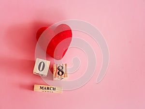 Decoration of wooden date blog cube for 8 March , international women`s day with a red heart shape on pink for celebration concep