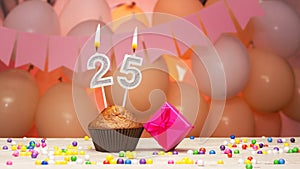 Decorations with balloons and a happy birthday candle with the number 25. Happy birthday greetings in pink flowers for twenty-five