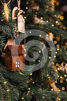 decorations on the Christmas tree close-up. vintage house on a branch and numerous bokeh