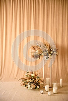 Decorations from dry beautiful flowers in a white vase on a beige fabric background