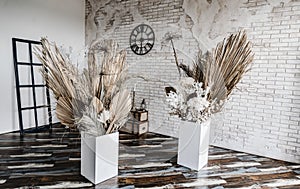 Decorations from dry beautiful flowers in a white vase on a beige fabric background. Home room decoration