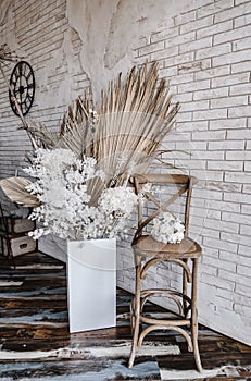 Decorations from dry beautiful flowers in a white vase on a beige fabric background. Home room decoration