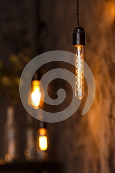 Decorative antique edison style light bulbs on the dark wall background. Loft interior details