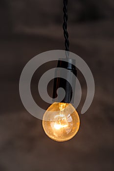 Decorative antique edison style light bulbs on the dark wall background. Loft interior details