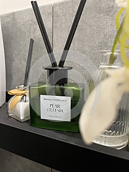 Stylish Reed Diffusers on Shelf with Grey Tile Background
