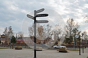 A decorative art object pointer stands in the central square against the background of Lenin Street of Yeniseisk city..