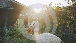 Decorative artificial plastic fake bird in backyard garden, stork imitation