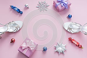 Decorative background pink Christmas composition Flat lay box gift ribbon bow snowflake sandals silver Christmas tree toys.