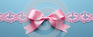 Decorative beautiful pink satin ribbon with bow for decorate gift box or greeting card on light blue background.