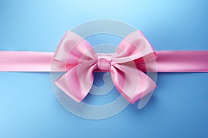 Decorative beautiful pink satin ribbon with bow for decorate gift box or greeting card on light blue background.