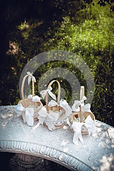 Decorative beige baskets with white rose petals for the wedding ceremony of the newlyweds