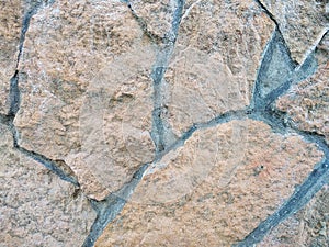 Decorative beige facing stone on the wall. The texture of the wall of the old stone