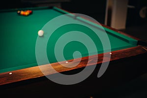 Decorative billiard hole and green table with balls in the billiard club
