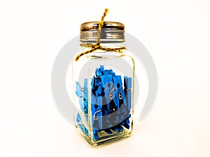 Decorative blue clothespins in a small jar