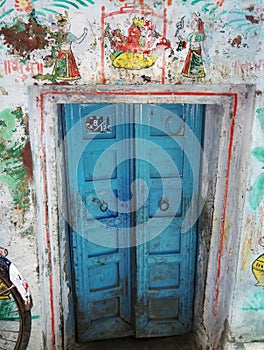 A decorative blue door gate of local residence in narrow alley between colourful houses in Varanasi, India. The old city of