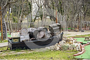 Decorative boat full of crate and barrel on a mini golf.