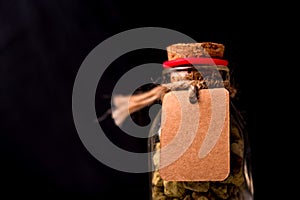 Decorative bottle with stones and label on black