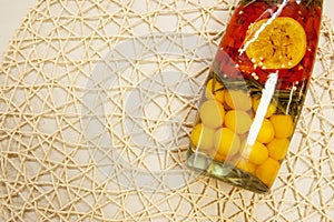 Decorative bottle with yellow and red fruits on a decorative mesh