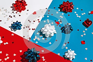 Decorative bows and heart shaped confetti on colorful geometric background. Valentine day theme.