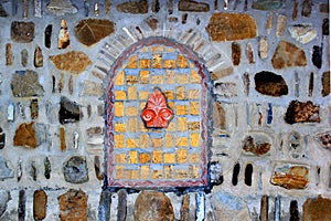 Decorative bricked window in a stone wall