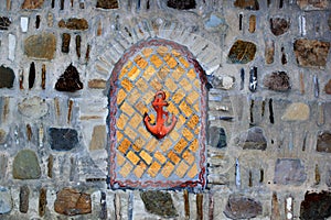 Decorative bricked window in a stone wall