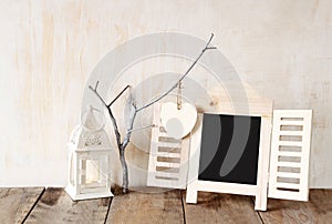 Decorative chalkboard frame and wooden hanging hearts over wooden table. ready for text or mockup. retro filtered image