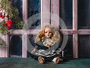 Decorative Christmas background of home cozy evening fir branch, with red decoraties.  Vintage beautiful doll sits on the