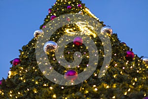 Decorative christmas ornaments baubles on green evergreen branches of a coniferous tree at the christmas markets in Prague