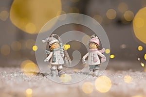 Decorative Christmas-themed figurines. Statuette boy and girl in knitted hats and scarves. Christmas tree decoration. Festive