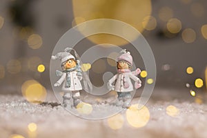 Decorative Christmas-themed figurines. Statuette boy and girl in knitted hats and scarves. Christmas tree decoration. Festive